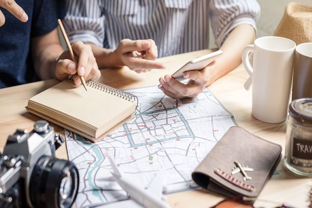 Travelers planning an Orlando vacation with a map, notebook and camera