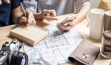 Travelers planning an Orlando vacation with a map, notebook and coffee