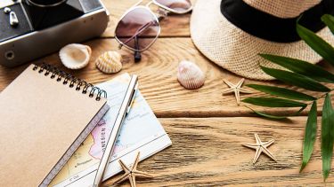 Camera, glasses, maps on the table, vacation planning