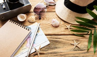 Camera, glasses, maps on the table, vacation planning
